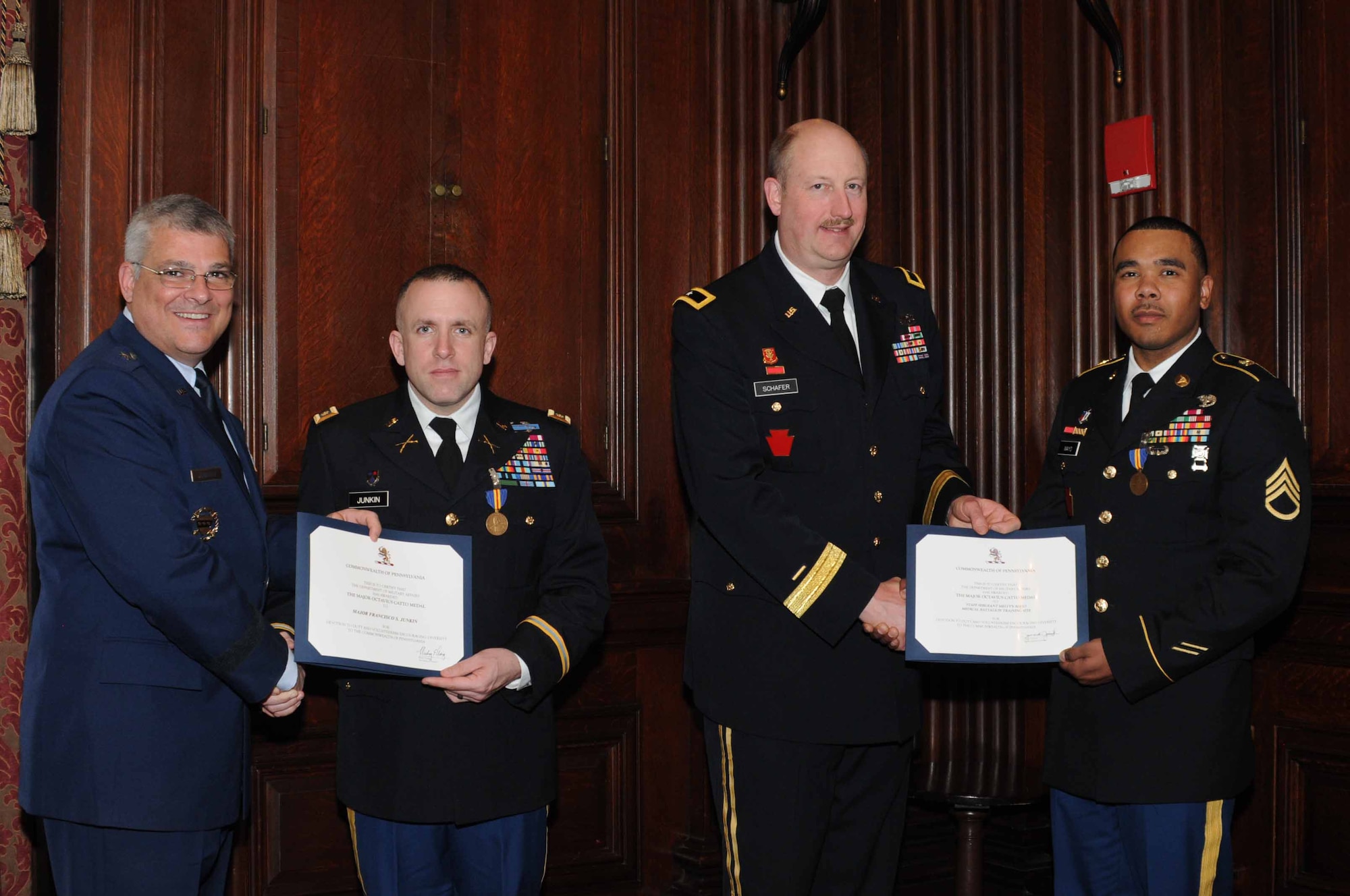 Deputy Adjutant General-Air of the Pennsylvania National Guard, Brig. Gen. Tony Carrelli, Joint Force Headquarters at Fort Indiantown Gap, Pennsylvania, congratulates Maj. Francisco S. Junkin, 56th Stryker Brigade Combat Team operations officer, Reading, Pennsylvania, while Brig. Gen. Andrew Schafer, 28th Infantry Division assistant commanding general at Fort Indiantown Gap, congratulates Staff Sgt. Melvyn L. Mayo Jr., Medical Battalion Training Site instructor also from Fort Indiantown Gap, after Junkin and Mayo accept the Major Octavius V. Catto Medal Feb. 21, 2015, at The Union League of Philadelphia, Philadelphia, Pennsylvania. The award bears the name of the Civil War-era African American leader and civil rights martyr from Philadelphia and is awarded to Guardsmen who display exemplary service and community support. (U.S. Air National Guard photo by Tech. Sgt. Andria J. Allmond/Released)