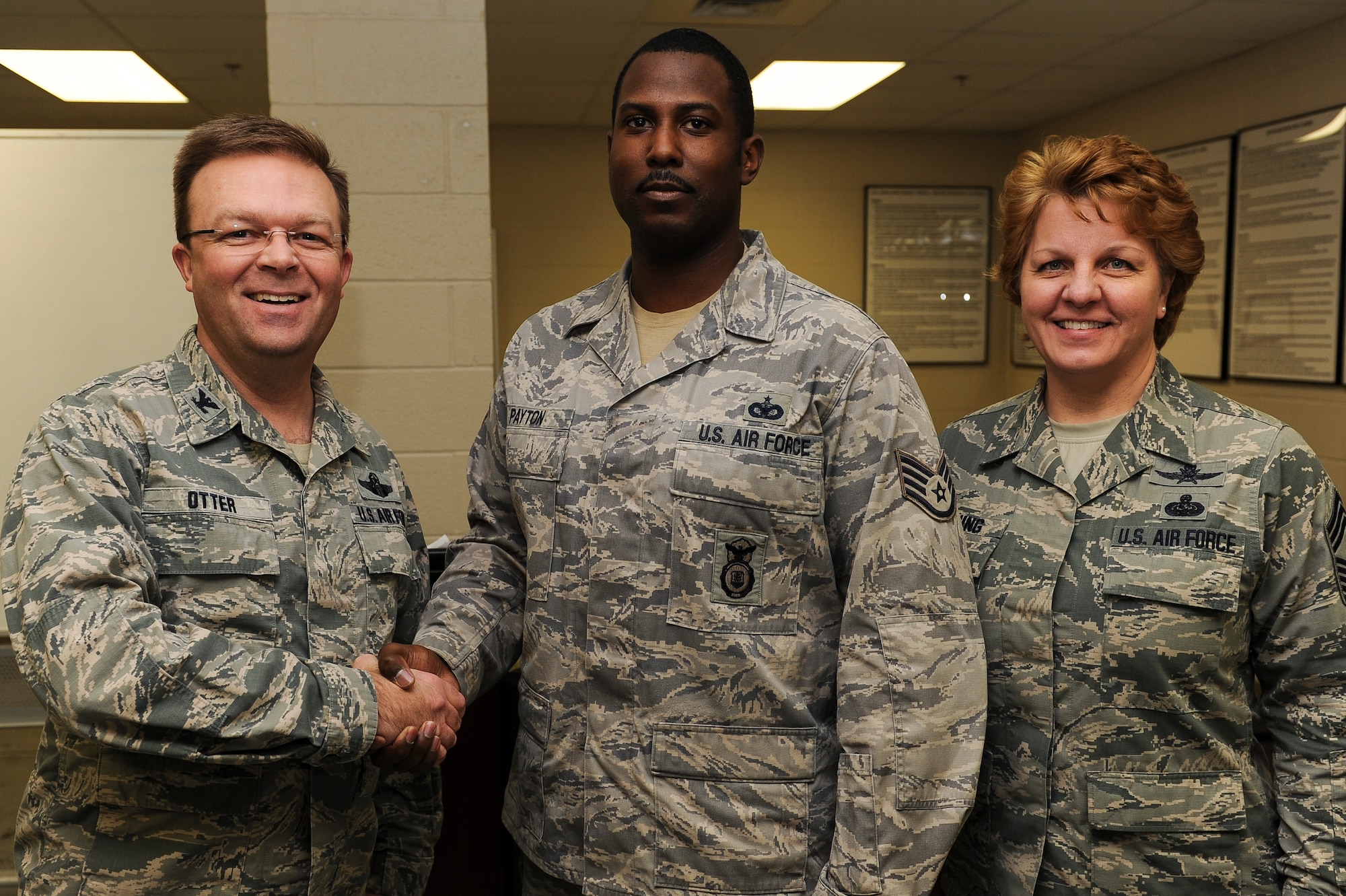 Col. William Otter, 19th Airlift Wing vice commander, and Chief Master Sgt. Rhonda Beuing, 19th Airlift Wing command chief congratulate Staff Sgt. William Payton, a 19th Security Forces Squadron patrolman, for his selection as Combat Airlifter of the Week Feb. 23, 2015, at Little Rock Air Force Base, Ark. Payton identified an unauthorized suspect attempting to gain access to Little Rock AFB. Upon further investigation it was revealed that the vehicle was stolen and the suspects were in possession of methamphetamine as well as drug paraphernalia. (U.S. Air Force photo/Senior Airman Cliffton Dolezal)