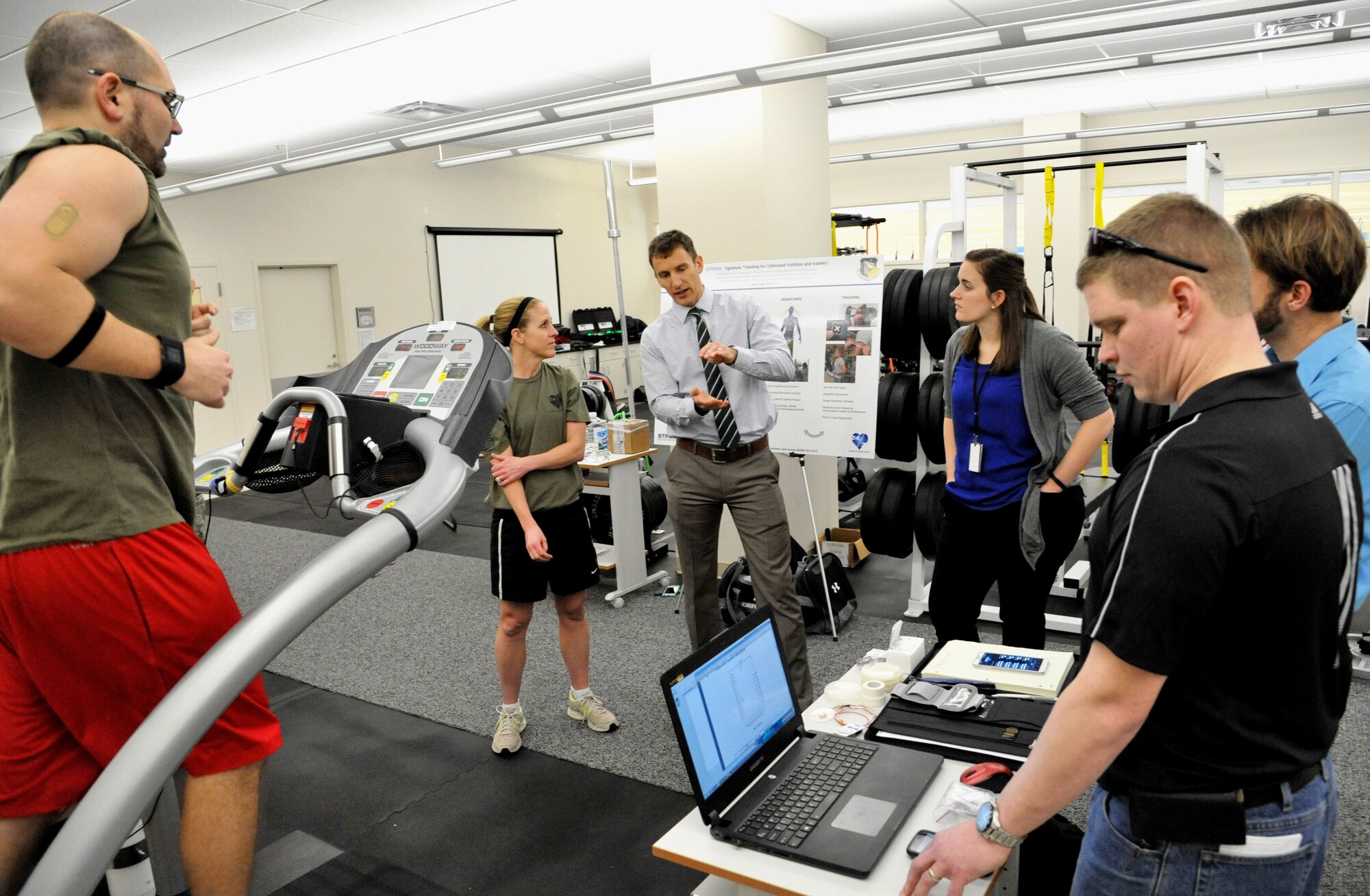 University of Cincinnati’s Novel Devices lab director and professor, Jason Heikenfeld (center), discusses with his research team how extreme physical stress can change the body’s chemistry. Air Force Research Laboratory researcher, Dr. Joshua Hagen, tests a new sweat sensor prototype on the treadmill while researchers from the University of Cincinnati monitor the trial at Wright-Patterson Air Force Base, Ohio, Feb. 11. The sweat sensor is the product of research collaboration between AFRL’s 711 HPW and the University of Cincinnati. “We have the potential to be able to tell the person if they are in their optimal (hydration) range and what to do if they’re not,” said Hagen.  (U.S. Air Force photo by Michele Eaton/88 ABW Public Affairs/Released)