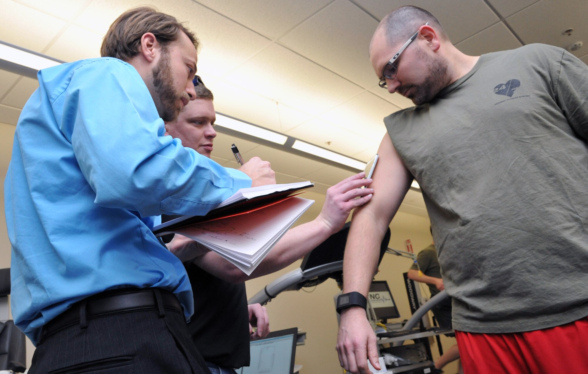 Researcher, Dr. Gavi Begtrup, and University of Cincinnati doctoral student, Daniel Rose, read Air Force Research Laboratory researcher, Dr. Joshua Hagen’s, sweat sensor using a smartphone app. The sensor, which is worn like a Band-Aid, tracks the user’s level of hydration, among other crucial markers of the body’s state after exercise. The research team, including the Air Force Research Laboratory’s 711th Human Performance Wing and the University of Cincinnati’s Novel Devices lab, conducted the first successful human trials of a usable sweat sensor prototype at Wright-Patterson Air Force Base, Ohio, Feb. 11. (U.S. Air Force photo by Michele Eaton/88 ABW Public Affairs/Released)