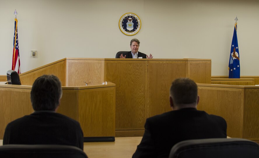 John Paradee (center), a civilian attorney and the honorary commander for the 512th Airlift Wing commander, checks out the view from the judge's bench inside the courtroom on Dover Air Force Base, Del., Feb. 25, 2015. He and other Team Dover honorary commanders visited the legal office as part of the Honorary Commander 101 Brief and Wing Staff Agency Tour. (U.S. Air Force Master Sgt. Veronica Aceveda)