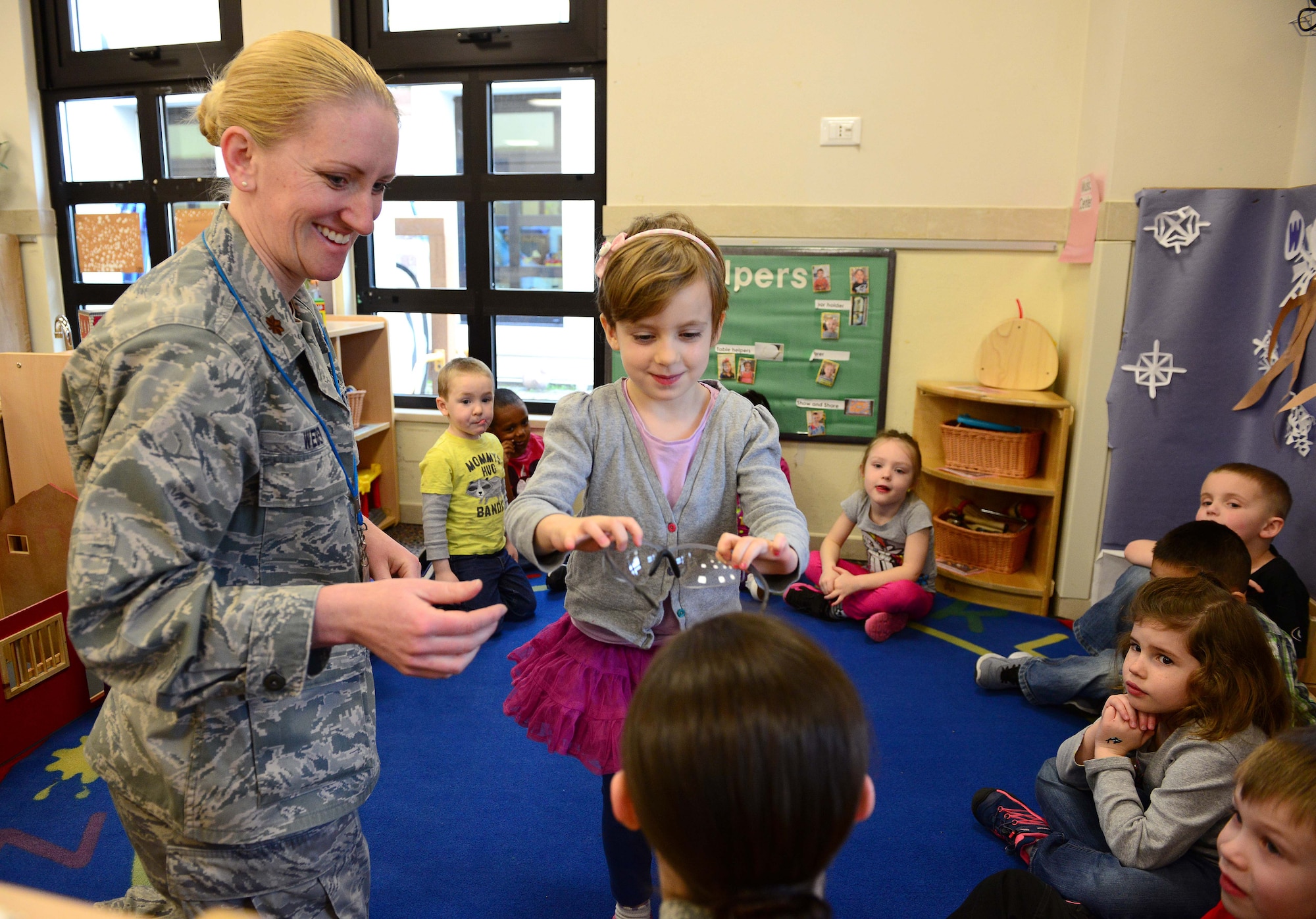 Elise, child of Brandyn and Jennifer Walter, places glasses on Senior Airman Jasmine Hanna, 31st Dental Squadron technician, during a visit to the child development center for National Children’s Dental Health Month, Feb. 26, 2015, at Aviano Air Base, Italy. In honor of month-long awareness, Airmen from the 31st DS visited schools and Child Development Centers around Aviano to help prevent bad hygiene starting at an early age. Aviano’s dentists and dental technicians provided oral health tips, facts about food intake and toothbrush kits. (U.S. Air Force photo by Senior Airman Matthew Lotz/Released)