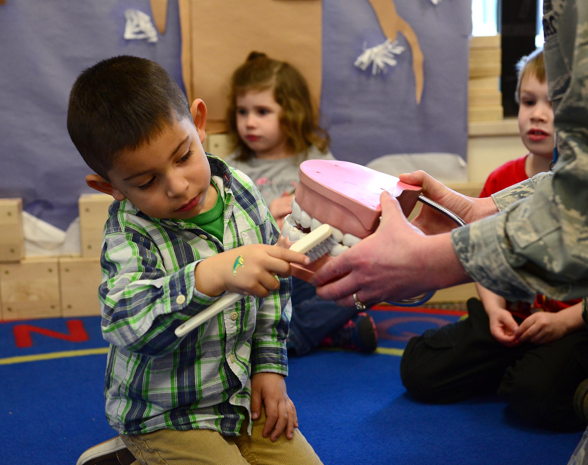 Mateo, child of Maurice and Jamie Carbajal, shows how he brushes teeth during National Children’s Dental Health Month, Feb. 26, 2015, at Aviano Air Base, Italy. In honor of National Children’s Dental Health Month, Airmen from the 31st Dental Squadron visited schools and Child Development Centers around Aviano to help prevent bad hygiene starting at an early age. Aviano’s dentists and dental technicians provided oral health tips, facts about food intake and toothbrush kits. (U.S. Air Force photo by Senior Airman Matthew Lotz/Released)