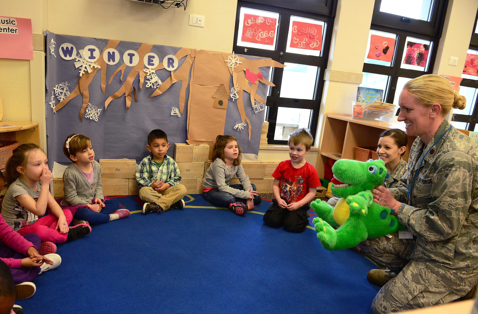 Maj. Rachel Weber, 31st Dental Squadron periodontist, speaks with children about the importance of good dental hygiene, Feb. 26, 2015, at Aviano Air Base, Italy. In honor of National Children’s Dental Health Month, Airmen from the 31st DS visited schools and Child Development Centers around Aviano to help prevent bad hygiene starting at an early age. Aviano’s dentists and dental technicians provided oral health tips, facts about food intake and toothbrush kits. (U.S. Air Force photo by Senior Airman Matthew Lotz/Released)