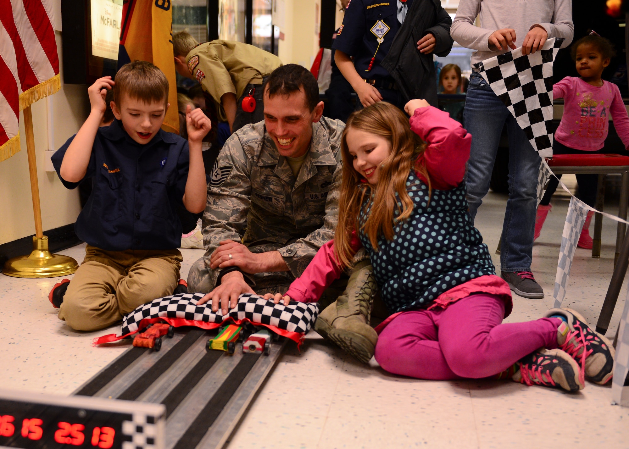 Cameron and Alexis Fisher, 8-year-old twins, cheer on boxcars with their father, Tech. Sgt. Christopher Fisher, 48th Civil Engineer Squadron NCO in charge of pavements and equipment, at the annual Cub Scout Pack 219 Pinewood Derby at the Exchange on Royal Air Force Lakenheath, England Feb. 24, 2015. Winners of RAF Lakenheath’s derby contests will compete in the Mayflower District race at RAF Feltwell on March 28th. (U.S. Air Force photo by Senior Airman Nigel Sandridge/Released)
