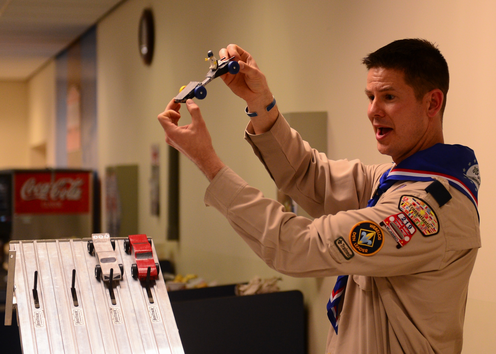 Lt. Col. David Kuch, 48th Medical Support Squadron flight commander, displays boxcar entries before a race at the Cub Scout Pack 219 Pinewood Derby at the Exchange on Royal Air Force Lakenheath, England, Feb. 24, 2015. All cars were made from a seven-inch piece of wood and had to be under the Boy Scouts of America-regulated five ounces to participate. (U.S. Air Force photo by Senior Airman Nigel Sandridge/Released)