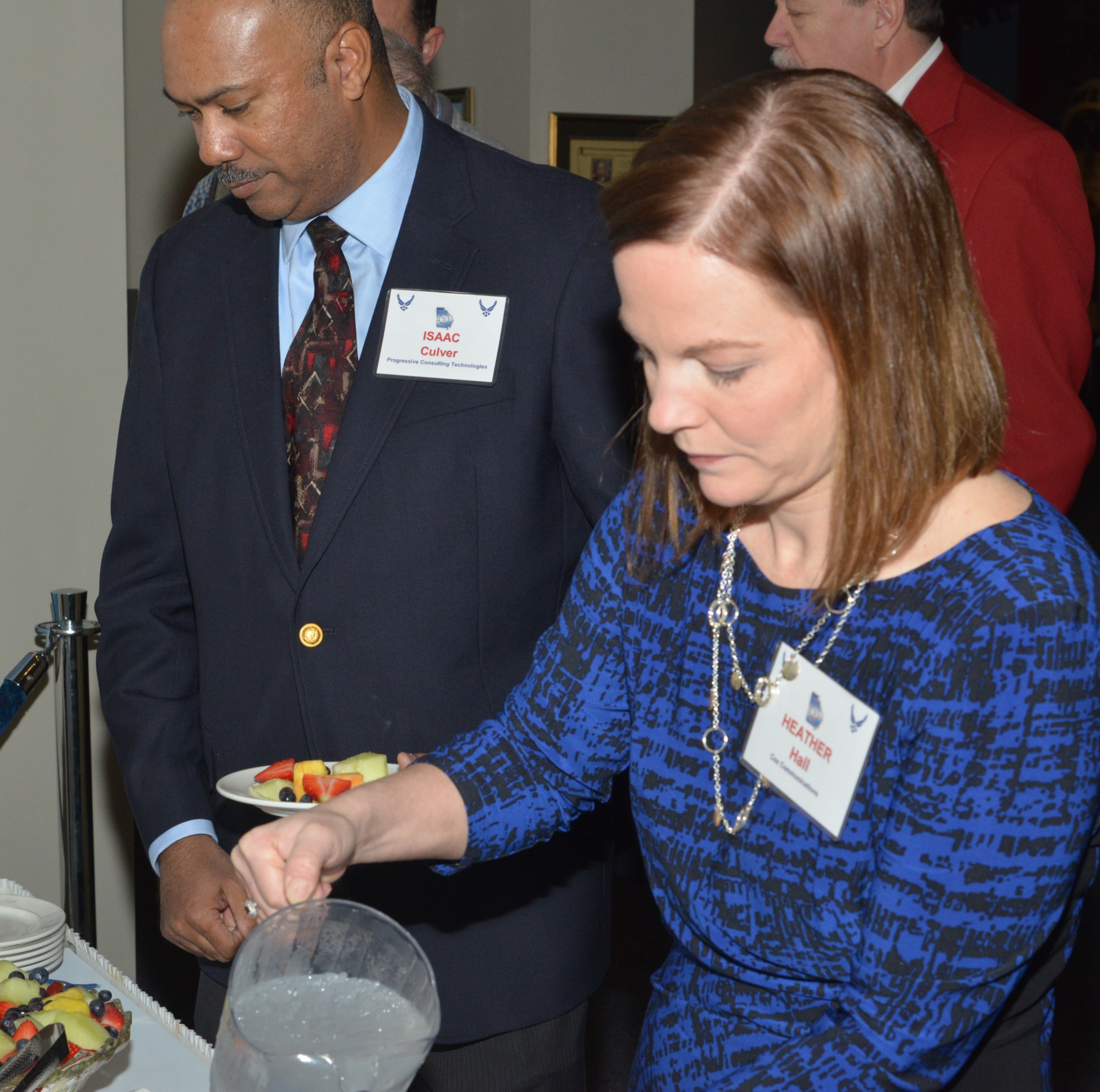 Heather Hall, marketing manager for Cox Communications and Isaac Culver, president of Progressive Consulting Technologies go through the serving line at the Honorary Commander’s Induction Ceremony, Feb.24, 2015. (U.S. Air Force photo by Ray Crayton)