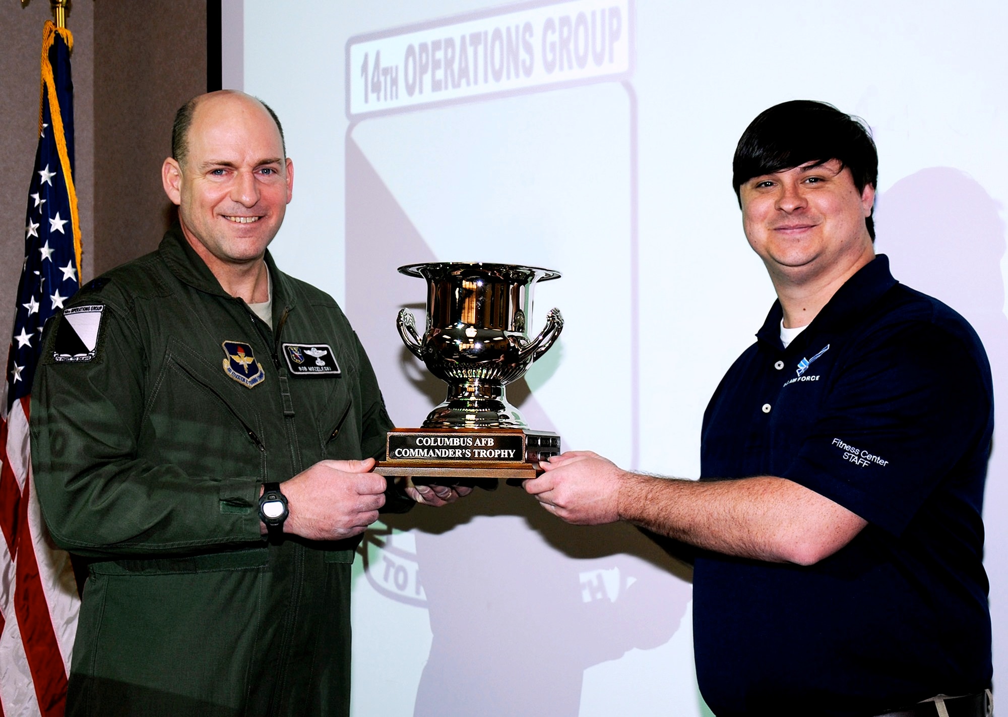 Lt. Col. Robert Mozeleski, 14th Operations Group Deputy Commander, accepts the Columbus Air Force Base Commander’s Trophy on behalf of the 14th OG from Tyler Marsh, Columbus AFB Sports Director, Feb. 24. The trophy is an annual award given to the group who collectively both participates and excels in the intramural sports program. (U.S. Air Force photo/Sharon Ybarra)
