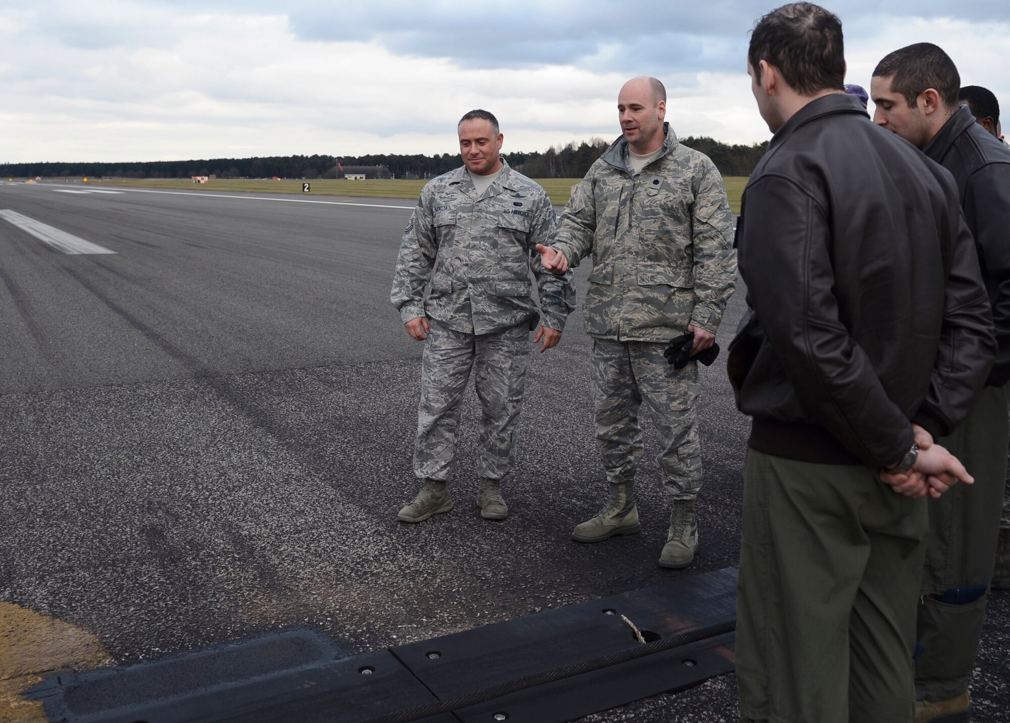 Lt. Col. Connor Blackwood, 48th Mission Support Group deputy commander, explains the importance of a repair on the flightline Feb. 25, 2015 at Royal Air Force Lakenheath, England. Airmen from the 48th Civil Engineer Squadron responded rapidly to repair the pothole, saving the 48th Fighter Wing millions of dollars in costs from diverting air traffic. (U.S. Air Force photo by Airman 1st Class Dawn M. Weber/Released)