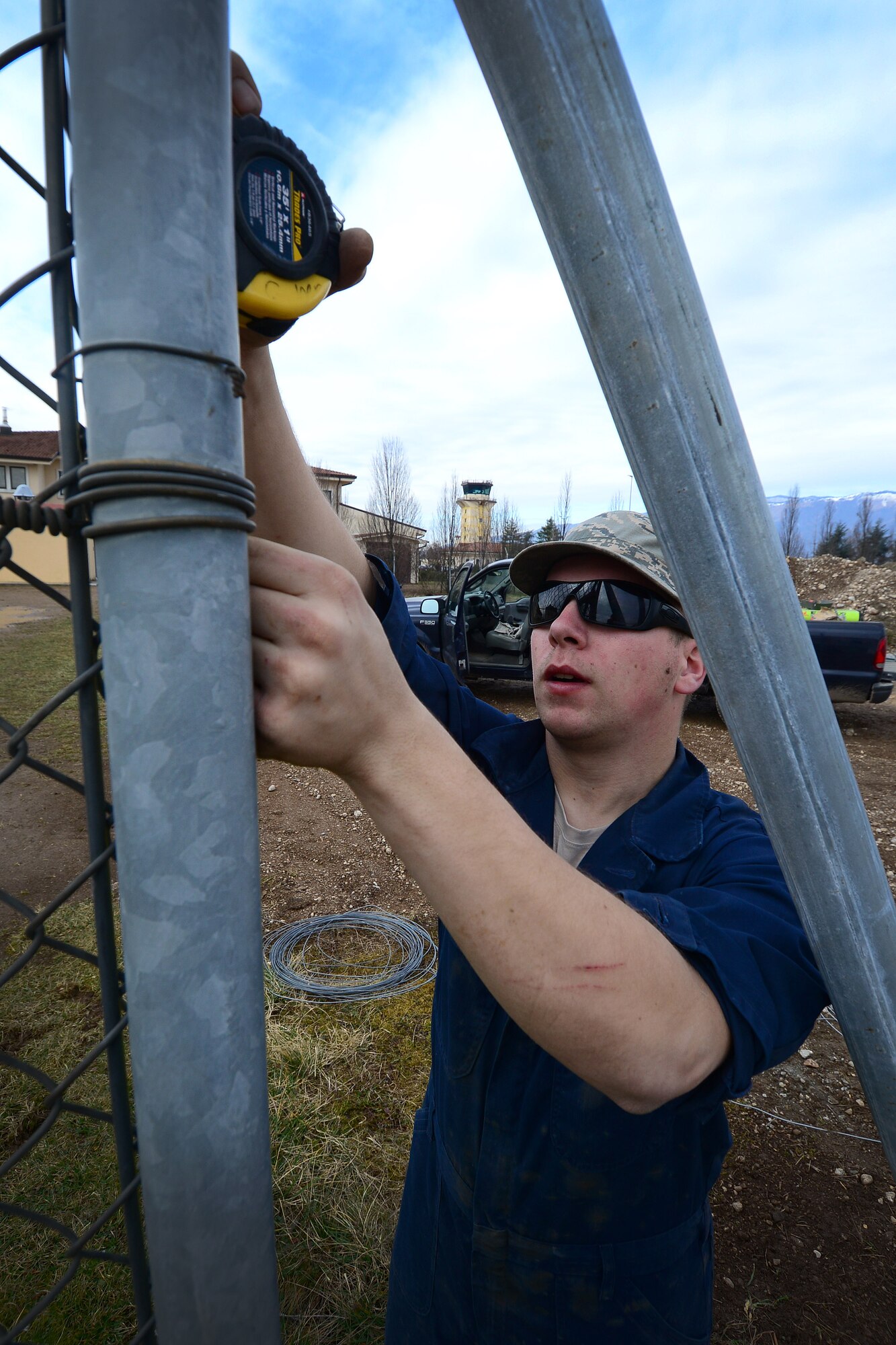 U.S. Air Force Senior Airman Bradley Ratz, 31st Civil Engineer Squadron pavement and construction journeyman, measures a fencepost, Feb. 23, 2015, at Aviano Air Base, Italy. Pavement and construction journeymen, also known as “dirt boys”, maintain security fencing for Aviano’s perimeter. (U.S. Air Force photo by Senior Airman Matthew Lotz/Released)