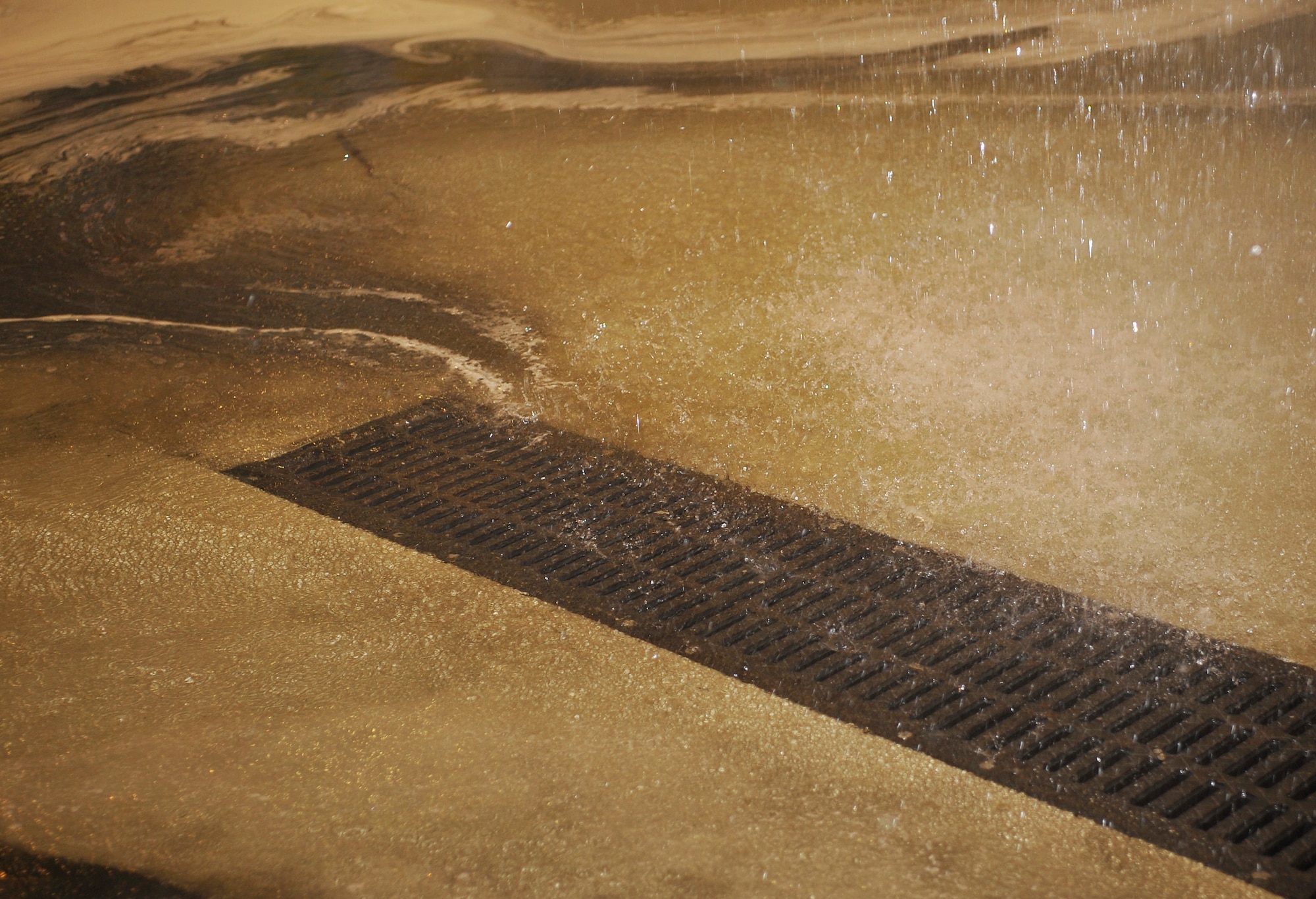 Water flows to drains in the floor of hangar five during a biennial fire suppression system test, Feb. 19, 2015 at Ramstein Air Base, Germany. The test is done to ensure the system is working properly and can affectively distinguish possible fires in the future. (U.S. Air Force photo/Airman 1st Class Larissa Greatwood)