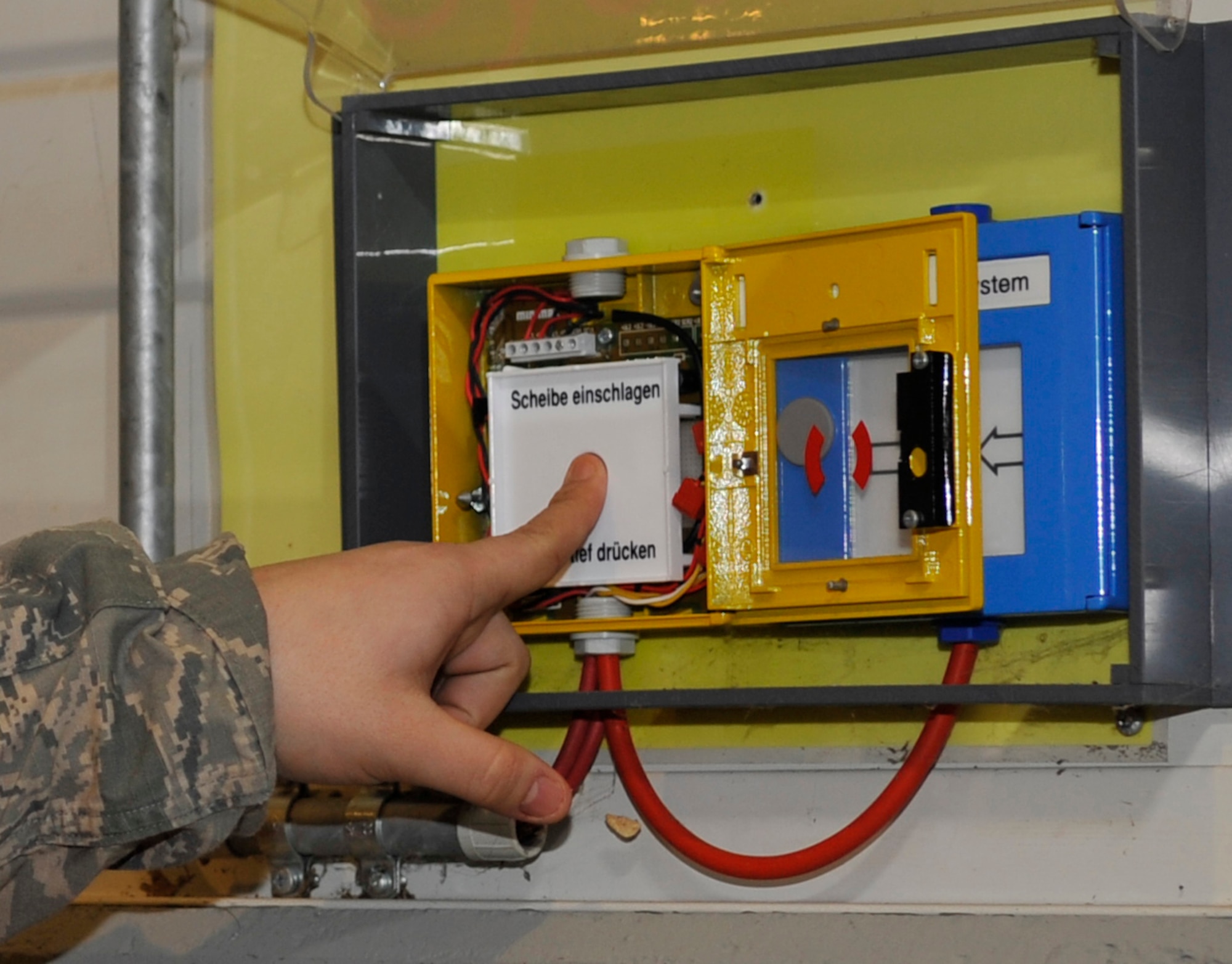 Senior Airman Nikko Miranda, 721st Aircraft Maintenance Squadron facility manager, presses the button to release water during a biennial fire suppression system test, Feb. 19, 2015 at Ramstein Air Base, Germany. Approximately 4,500 gallons of water per minute was emitted from a 40,000 gallon tank. The hangar was closed for two days to conduct the test. (U.S. Air Force photo/Airman 1st Class Larissa Greatwood)