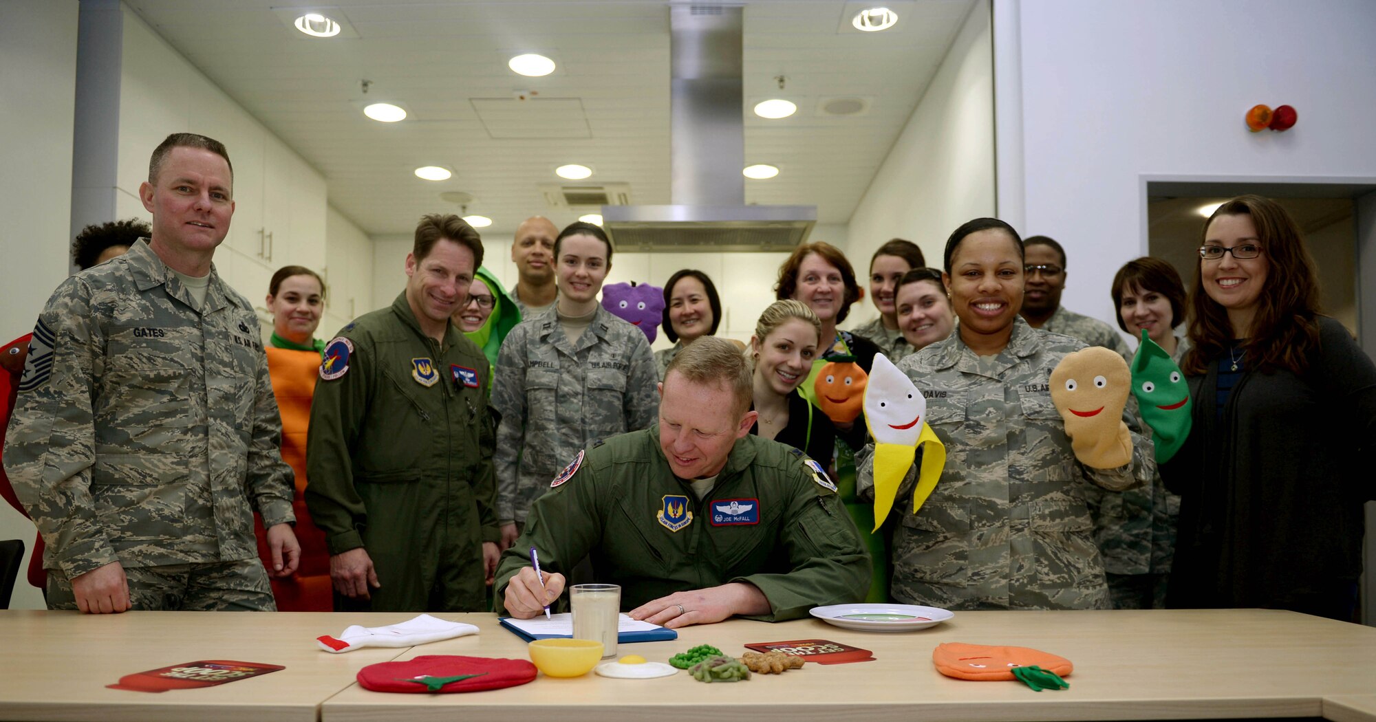 U.S. Air Force Col. Joe McFall, 52nd Fighter Wing commander, seated center, signs a proclamation alongside base community members during a National Nutrition Month kickoff event in the Spangdahlem Health Promotion’s kitchen at Spangdahlem Air Base, Germany, Feb. 26, 2015. The proclamation designated the month of March as National Nutrition Month and encouraged Spangdahlem community members to make informed food choices and develop sound eating and physical activity habits. (U.S. Air Force photo by Airman 1st Class Timothy Kim/Released)