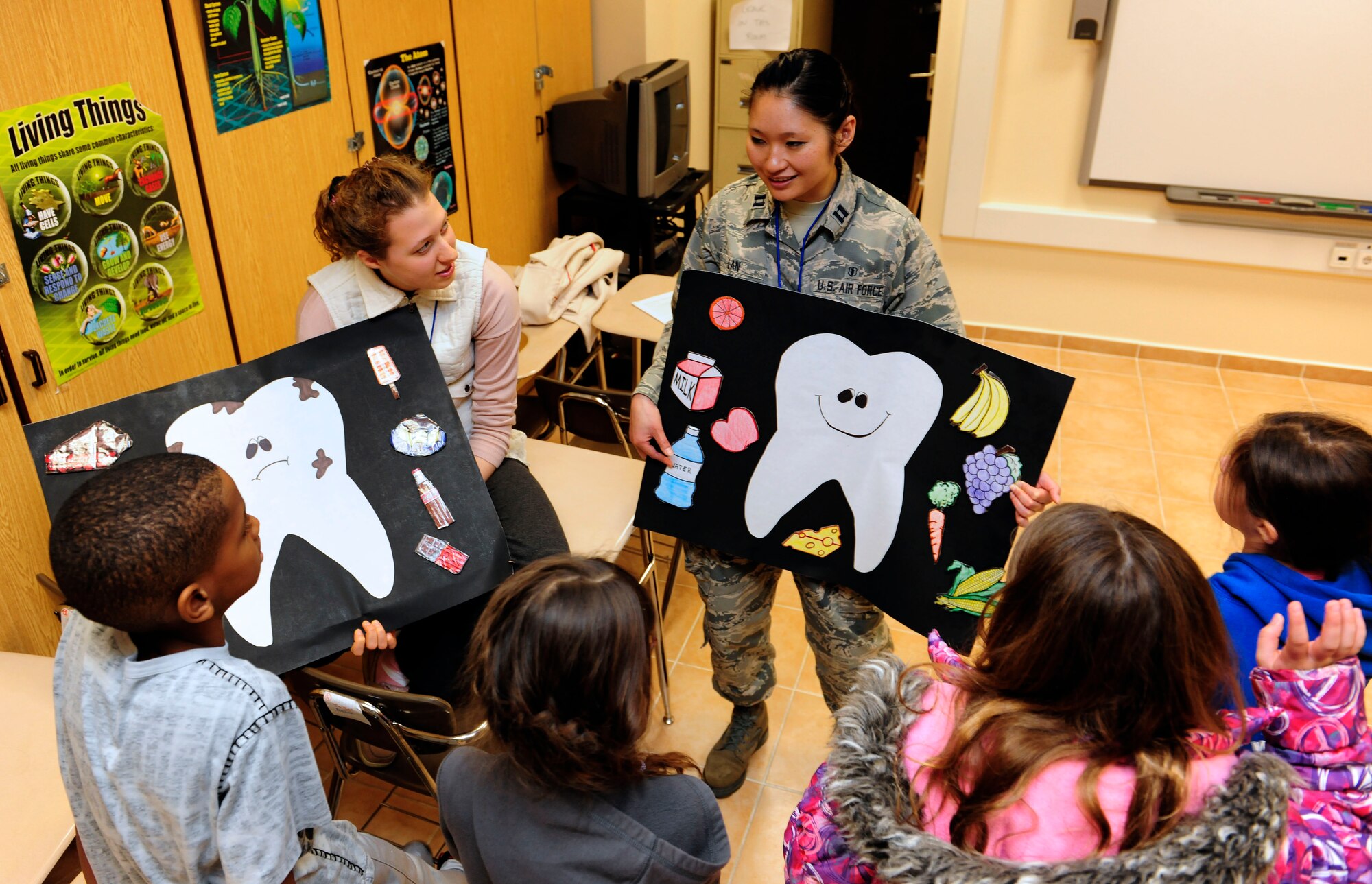 Dorthy Tisdel, American Red Cross volunteer, and Capt. Cindy Lan, 39th Medical Operations Squadron dentist, speak to a group of fourth-grade students about dental hygiene Feb. 24, 2015, at Incirlik Air Base, Turkey. Tisdel and Lan educated the students on foods that were healthy and unhealthy for teeth. (U.S. Air Force photo by Senior Airman Krystal Ardrey/Released)