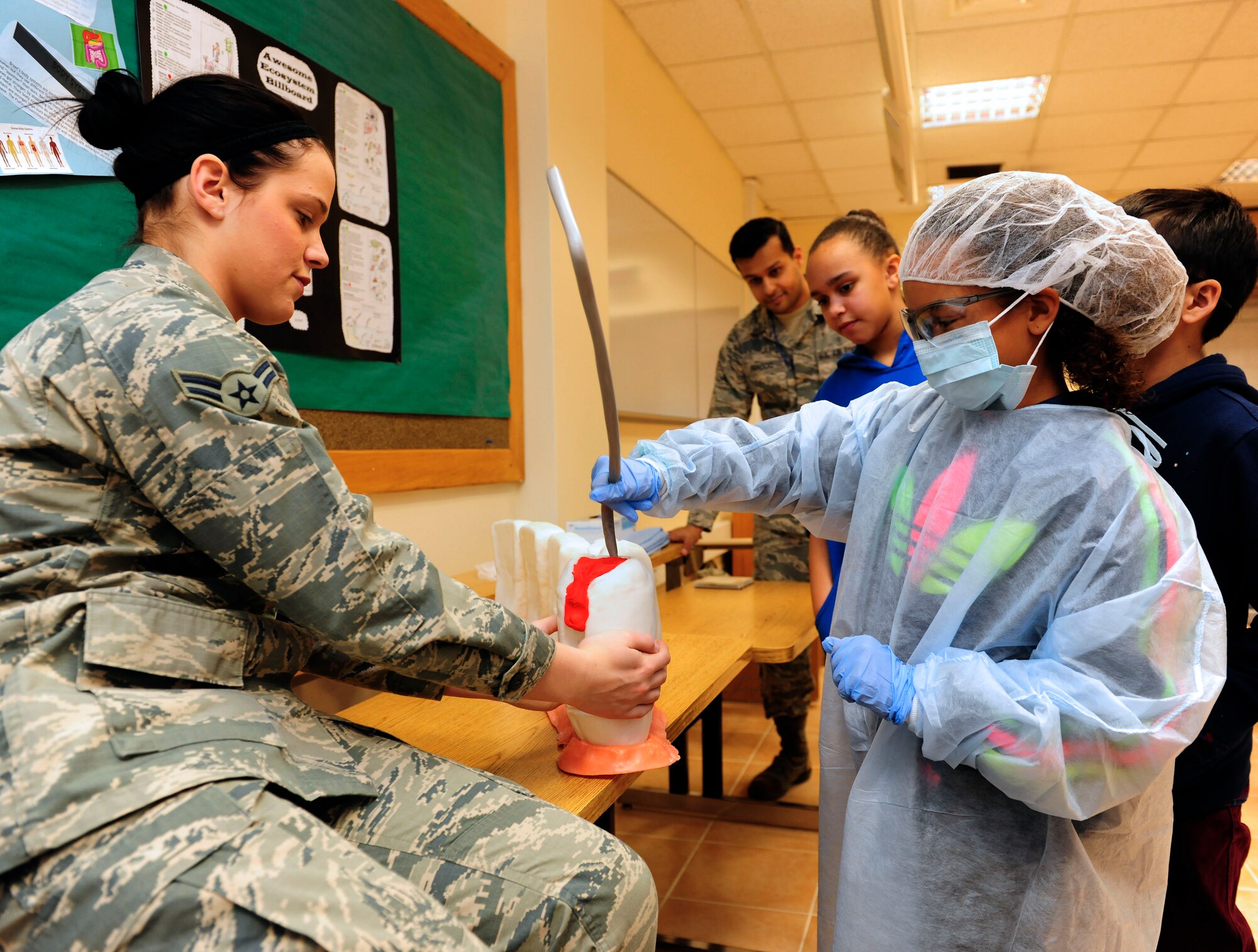 Airman 1st Class Savannah Ziegler, 39th Medical Operations Squadron dental assistant, teaches Cai Rogers, fourth-grade student, how to remove a cavity Feb. 24, 2015, at Incirlik Air Base, Turkey. Ziegler visited the school with a group of Airmen from the 39th MDOS to teach the students about dental health. (U.S. Air Force photo by Senior Airman Krystal Ardrey/Released)