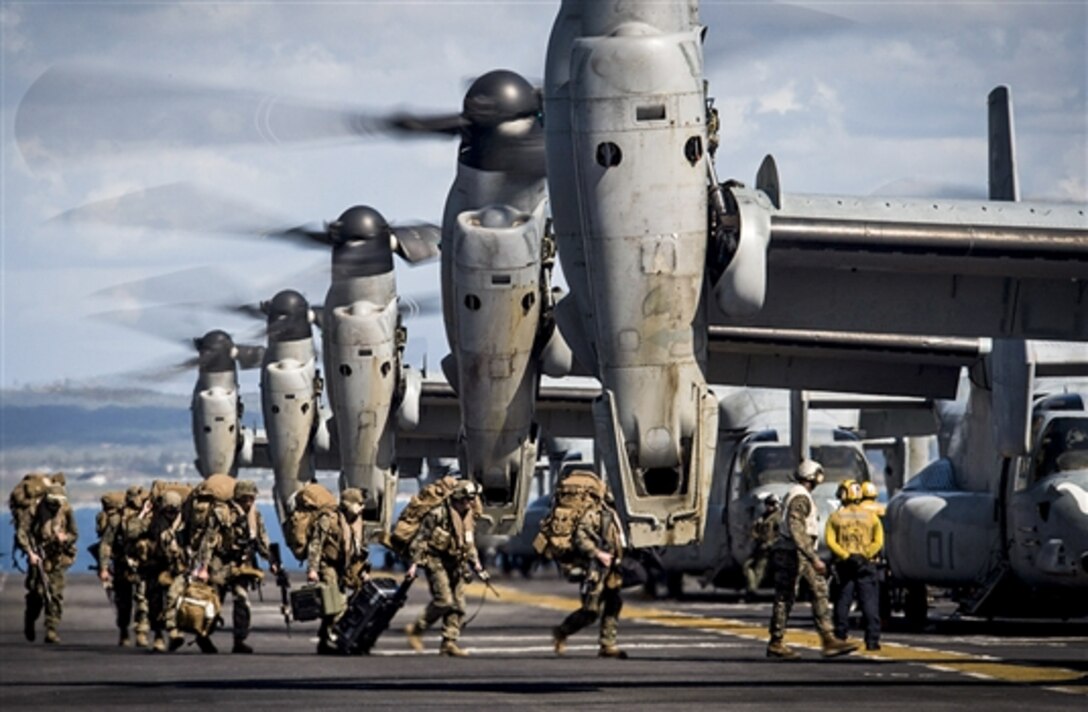 Marines board MV-22 Ospreys before they take off from the flight deck of the amphibious assault ship USS Makin Island off the coast of Camp Pendleton, Calif., Feb. 23, 2015. 
