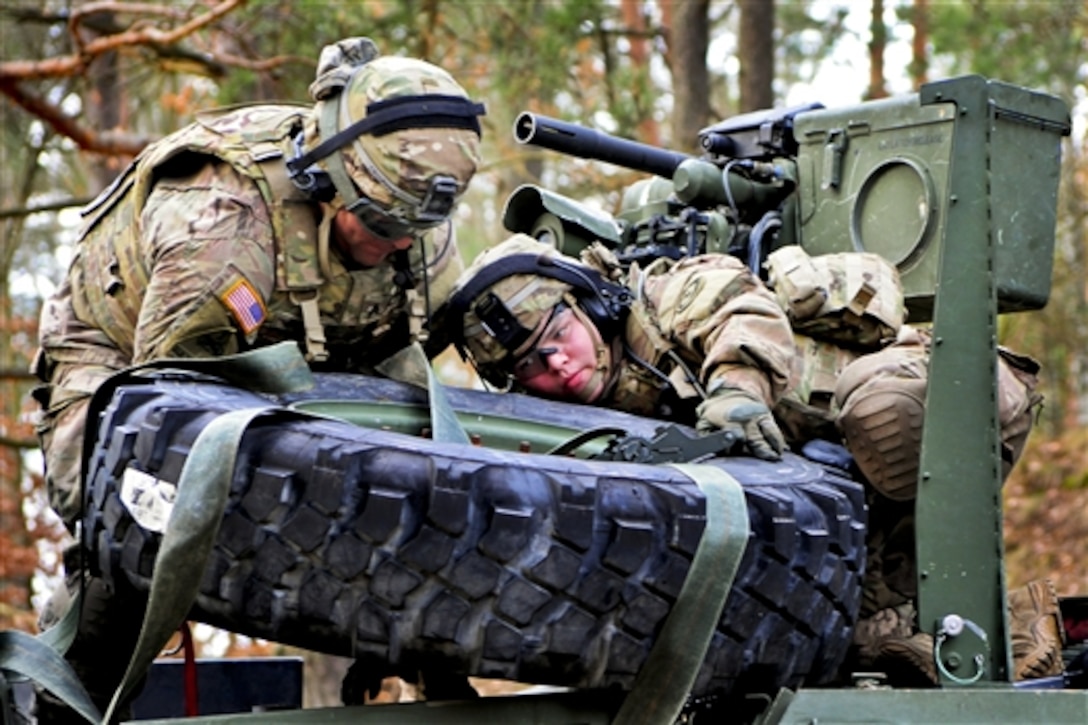 U.S. soldiers secure a tire to a Stryker armored vehicle during Operation Atlantic Resolve in the Drawsko Pomorskie training area, Poland, Feb. 24, 2015. The soldiers are assigned to 3rd Squadron, 2nd Cavalry Regiment.  