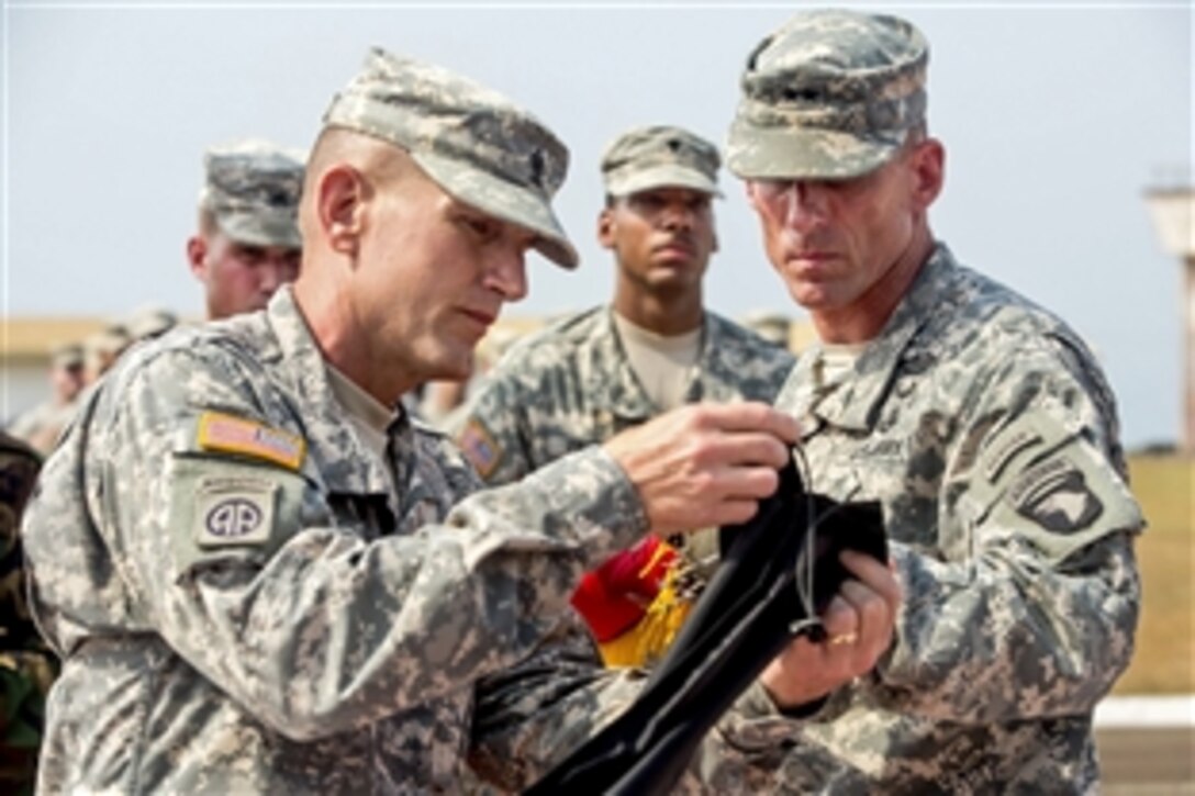 U.S. Army Maj. Gen. Gary J. Volesky, right, commander of Joint Forces Command United Assistance and the 101st Airborne Division, and U.S. Army Command Sgt. Maj. Gregory Nowak, left, senior enlisted advisor for the command and division, case their unit colors during a ceremony at the Barclay Training Center in Monrovia, Liberia, Feb. 26, 2015. 