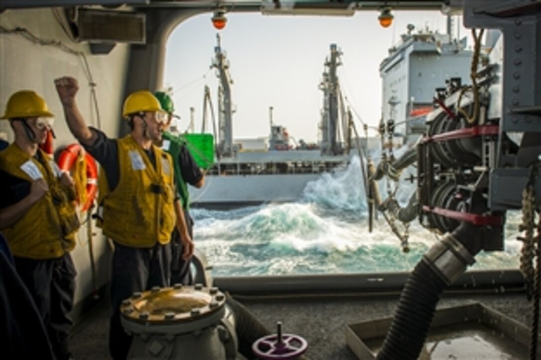 U.S. Navy Petty Officer 2nd Class Timmothy Annoni signals as a fuel probe seats to the aircraft carrier USS Carl Vinson during a replenishment with the Military Sealift Command fleet replenishment oiler USNS Walter S. Diehl in the Persian Gulf, Feb. 18, 2015. The carrier is supporting Operation Inherent Resolve, conducting strike operations in Iraq and Syria as directed.