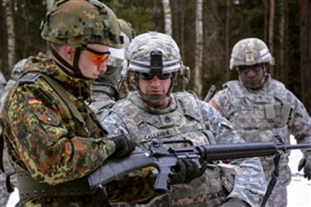 U.S. Army Staff Sgt. James Callahan inspects a German soldier's M16 rifle before entering the firing range in Grafenwoehr Training Area in Grafenwöhr, Germany, Feb. 19, 2015. Callahan is a platoon sergeant assigned to Company C, 44th Expeditionary Signal Battalion. The German soldier is assigned to the 383rd Communications and Information Systems Battalion.

