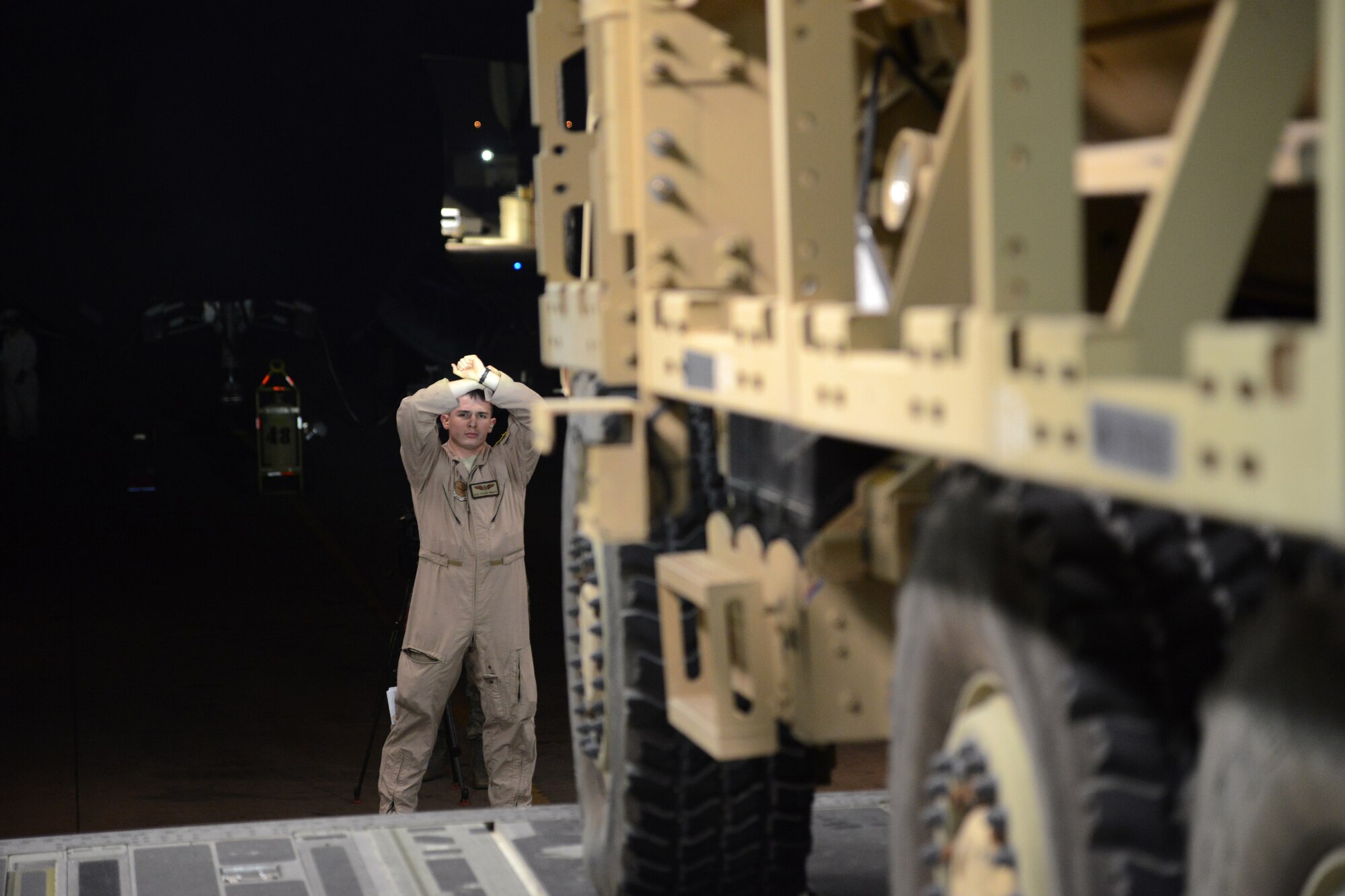 Airman 1st Class Tyler Pruitt, 386th Air Expeditionary Operations Group, guides the last to two Mine Resistant Armored Personnel carriers on a C-17 Globemaster III bound for Erbil, Iraq, Dec. 30, 2014. The MRAPs are for the Iraqi Security Forces and Peshmerga to aid in the fight against Daish. (U.S. Air force photo by Tech. Sgt. Jared Marquis/released)