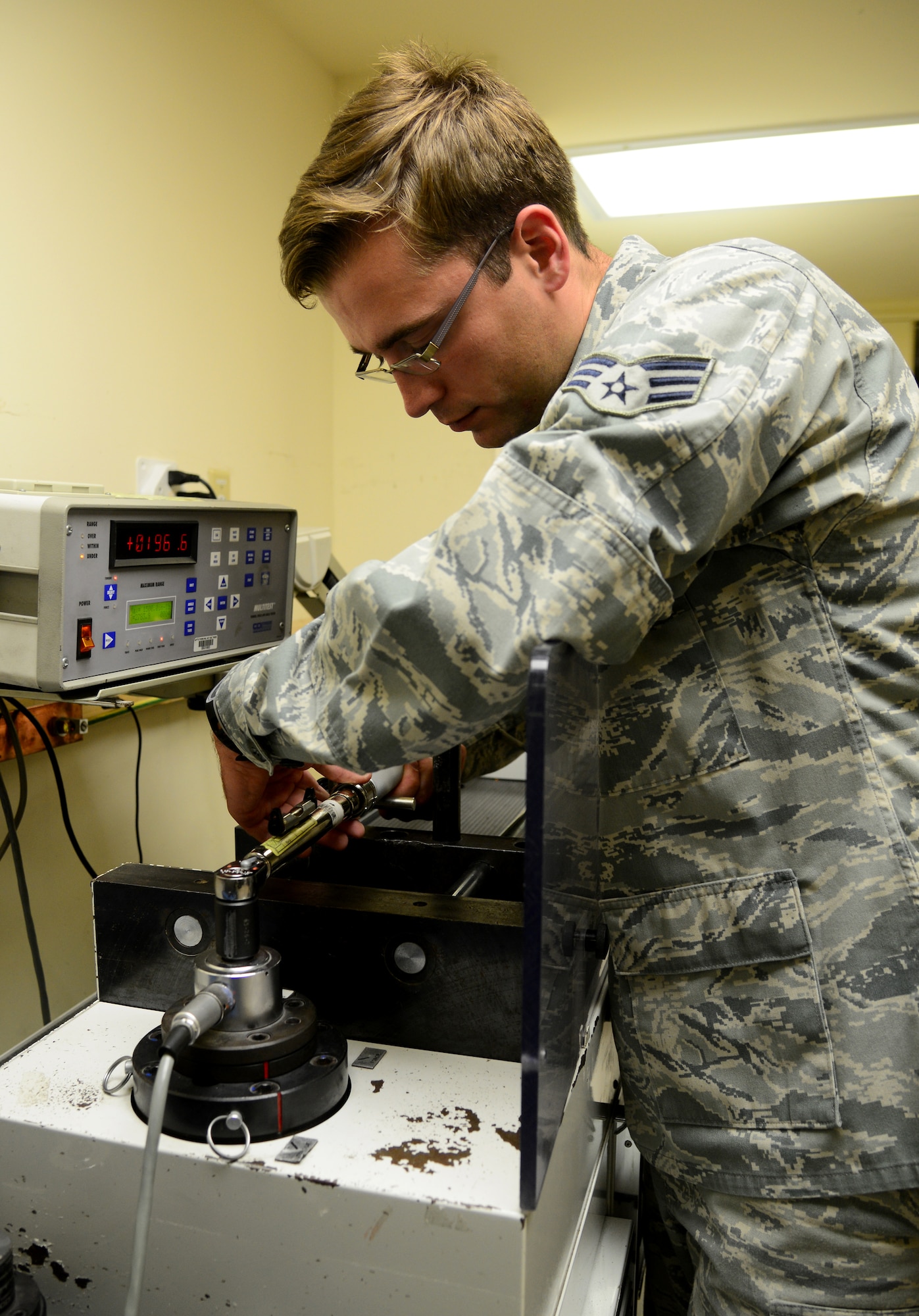 U.S. Air Force Senior Airman Jeffrey Tyler, 379th Expeditionary Maintenance Squadron Precision Measurement Equipment Laboratory technician, calibrates a torque wrench, Dec. 31, 2014, at Al Udeid Air Base, Qatar. PMEL Airmen have many tools or what they call “standards” to ensure everything is accurately calibrated. Tyler is deployed from Ramstein Air Base, Germany. (U.S. Air Force photo by Senior Airman Kia Atkins)