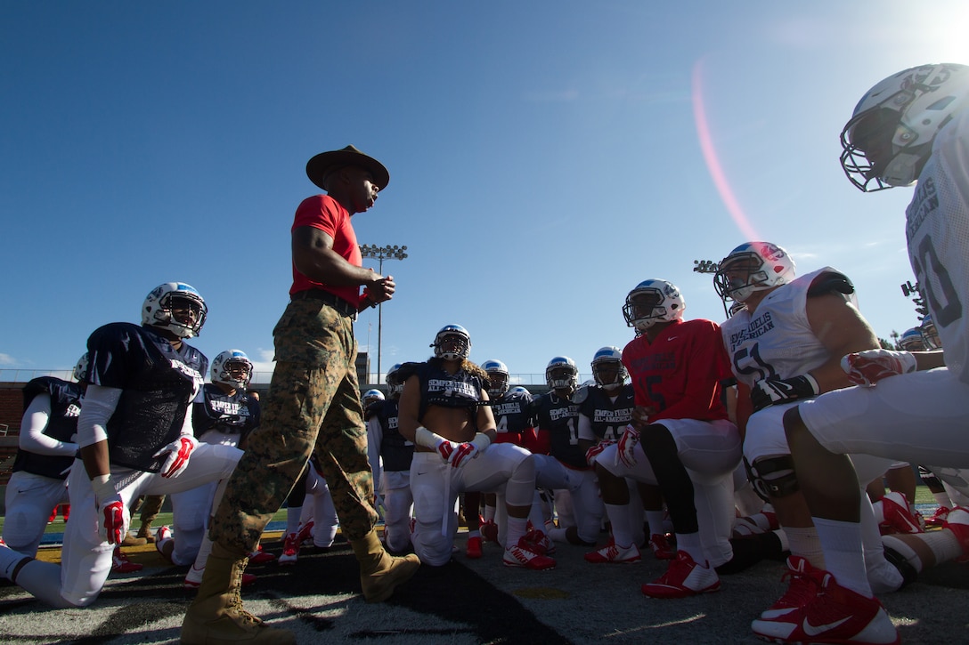 U.S. Marine Corps Staff Sgt. John L. Walker Jr., a drill instructor from Marine Corps Recruit Depot San Diego, speaks with Semper Fidelis All-American football players [West Team], concluding the team’s first practice at Santa Ana Stadium in Santa Ana, Calif., Dec. 31, 2014. In preparation for the Semper Fidelis All-American Bowl, Walker and other drill instructors spend time with the players to share their Marine Corps’ experiences with the student-athletes. The bowl, featuring 99 players from across the country, will be nationally televised live from the StubHub Center in Carson, Calif., at 6 p.m. (PST) on Jan. 4, 2015, on Fox Sports 1. (U.S. Marine Corps photo by Sgt. Tyler J. Bolken/Released)
