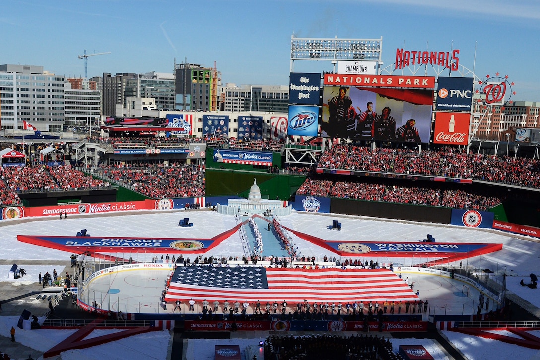 Service members take part in a flag ceremony on the ice in Nationals Park, Washington, D.C., before the start of the 2015 Bridgestone NHL Winter Classic hockey game between the Washington Capitals and Chicago Blackhawks, Jan. 1, 2015. The National Hockey League paid tribute to the U.S. Armed Forces during pre-game and in-game festivities.  Other events featured performances by the U.S. Armed Forces Color Guard, the U.S. Army Chorus and U.S. Army Herald Trumpets, singers Army Master Sgt. Bob McDonald and Master Sgt. Caleb Green singing the National Anthem and a flyover by the D.C. Air National Guard's 113th Wing.