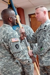 Army Capt. Brent Middleton, left accepts his unit's flag from his battalion commander in a change-of-command ceremony at Camp Mabry, Texas, March 20, 2010.