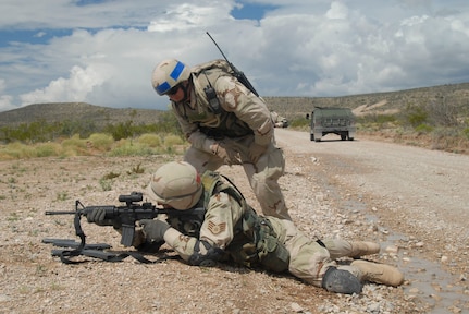 A 204th Security Forces Squadron instructor assists a National Guard Airman during combat support training on Fort Bliss, Texas.