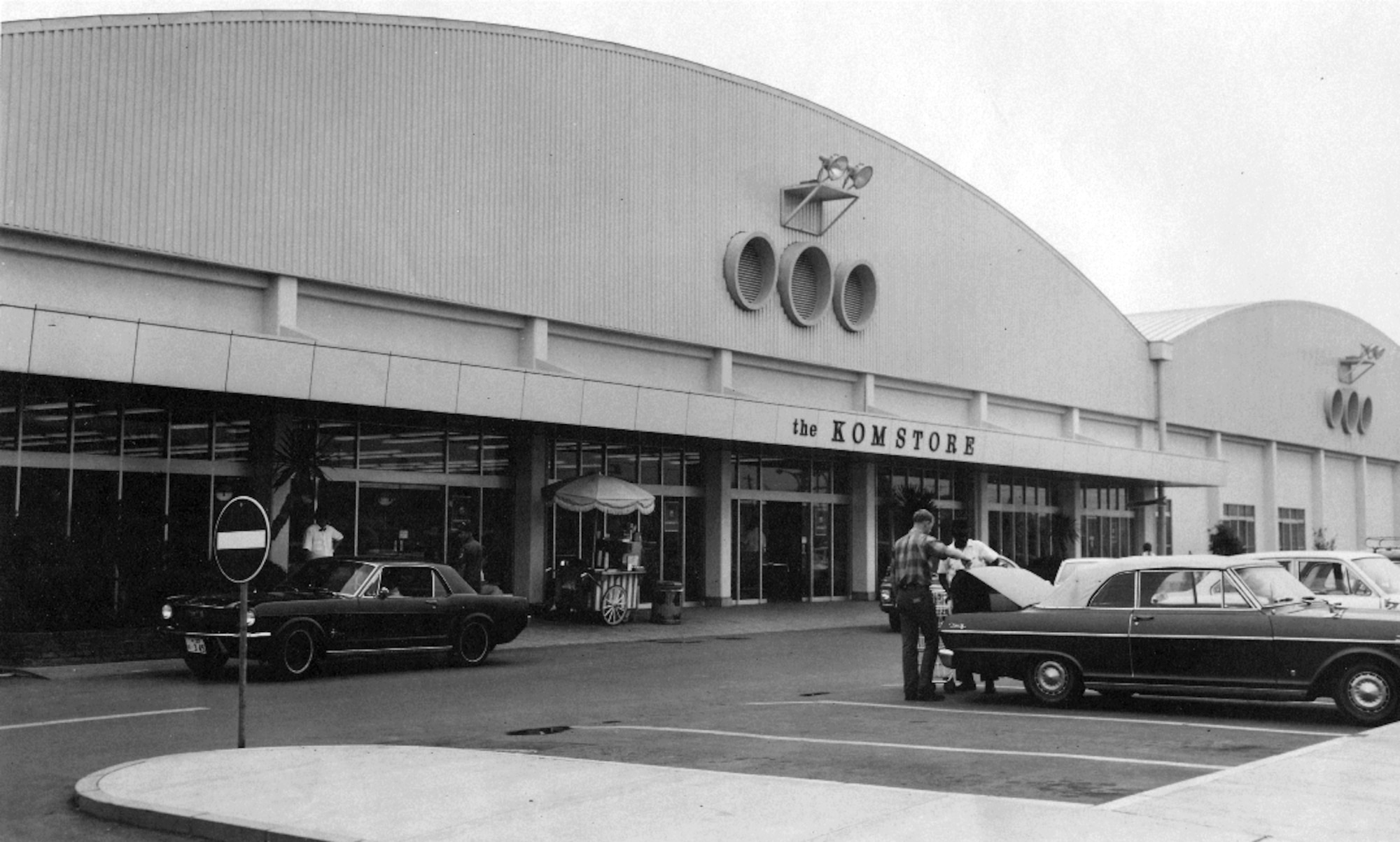A 1970s photo of Yokota's BXtra building with its unmistakable portholes.
The building was originally constructed as a commissary, and was one of many
new facilities built during the early 1970s under KPCP. At that time it was
called the "Komstore”. (Photo courtesy of the 374th 
Airlift Wing History Office)
