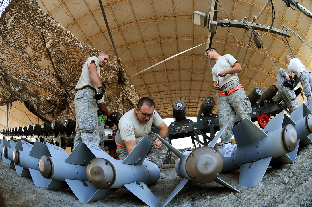 Master Sgt. Adam, middle, NCO-in-charge of conventional maintenance, preps the KMU-572 fins for assembly onto the MK-82 munition Dec. 21, 2014, in Southwest Asia.  Adam is deployed from Seymour Johnson Air Force Base, N.C. (U.S. Air Force photo/Senior Master Sgt. Carrie Hinson)