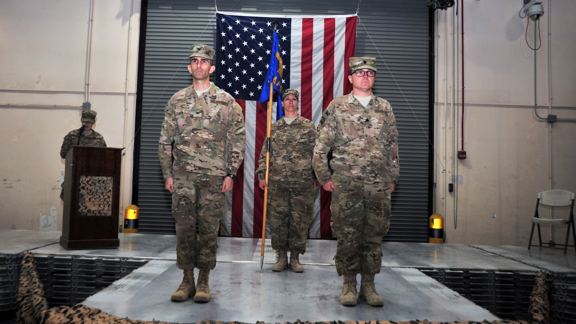 U.S. Air Force Col. Michael Grogan, 455th Expeditionary Mission Support Group commander, U.S. Air Force Lt. Col. Christopher Carmichael, 455th Expeditionary Aerial Port Squadron commander, and Master Sgt. Tricia Pinola, 455 MSG first sergeant, stand at attention during the reading of an inactivation order Jan. 1, 2014 at Bagram Airfield, Afghanistan. The 455 EAPS was officially deactivated following six years of operations during which Airmen moved more than 1.1 million tons of cargo and 2.4 million passengers over 204,000 missions since its activation in 2008. . (U.S. Air Force photo by Staff Sgt. Whitney Amstutz/released)