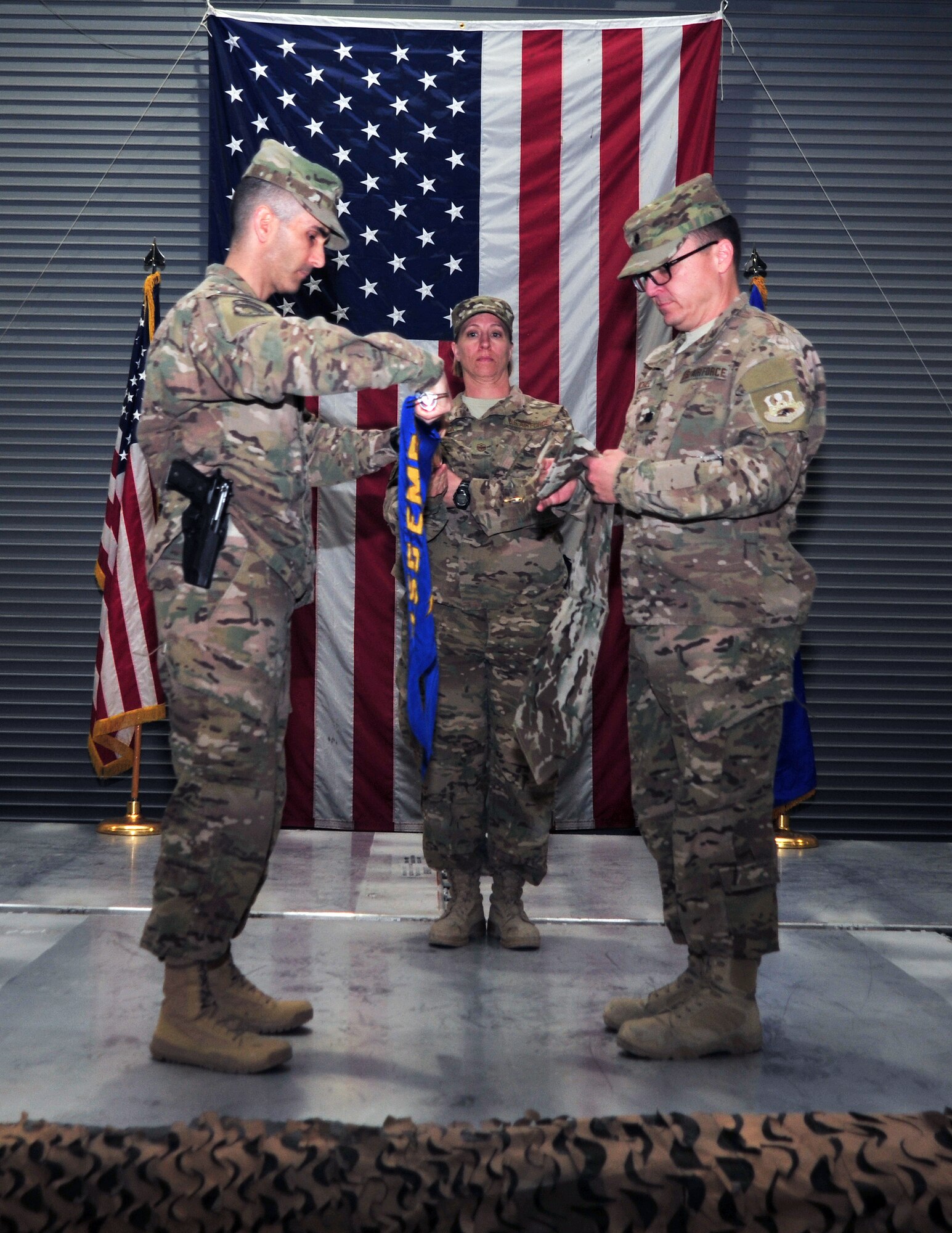 U.S. Air Force Col. Michael Grogan, 455th Expeditionary Mission Support Group commander, furls the 455th Expeditionary Aerial Port Squadron colors during a squadron inactivation ceremony Jan. 1 at Bagram Airfield, Afghanistan. The squadron, now belonging to the 455th Expeditionary Logistics Readiness Squadron, will henceforth be recognized as an aerial port flight. (U.S. Air Force photo by Staff Sgt. Whitney Amstutz/released)