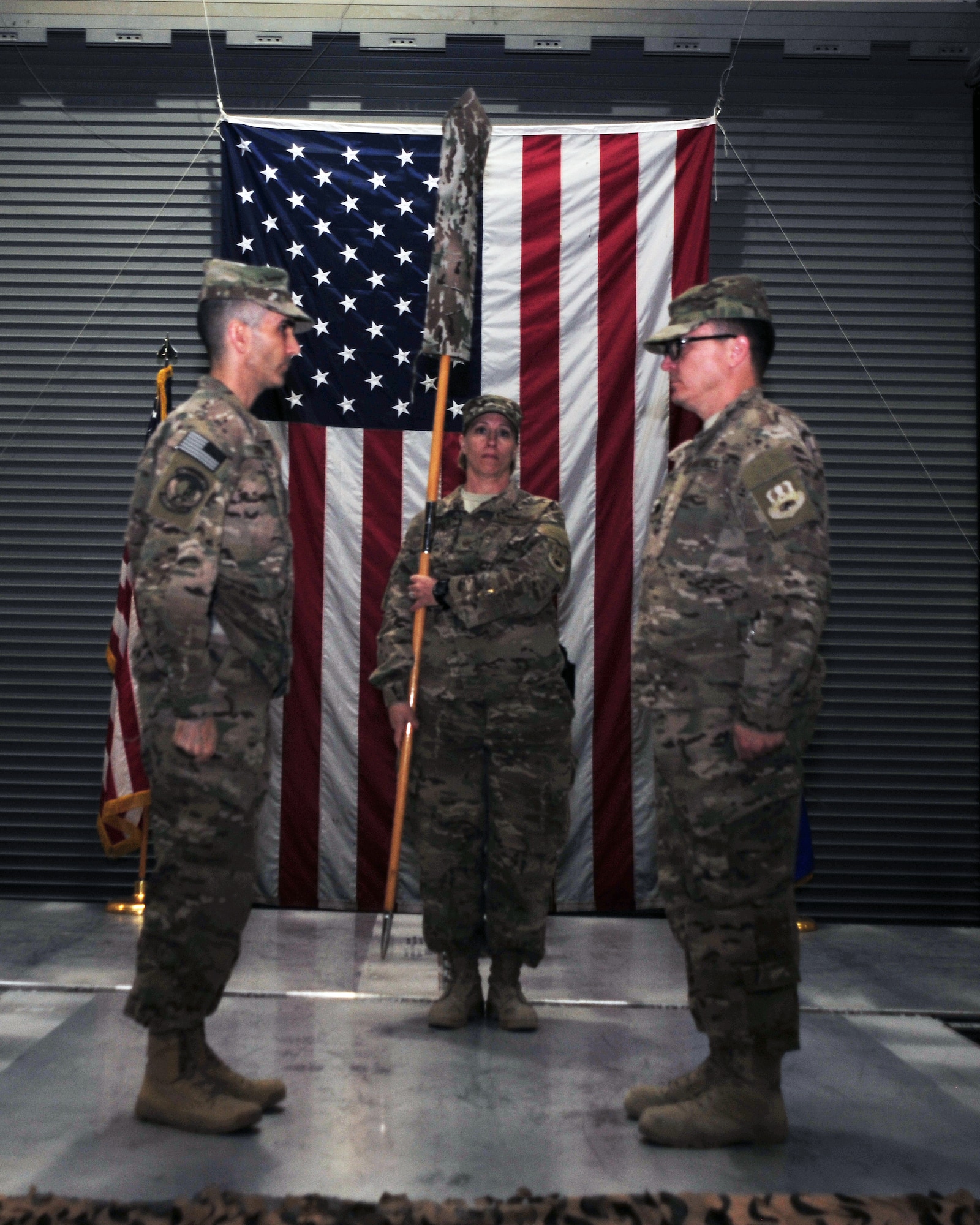 U.S. Air Force Col. Michael Grogan, 455th Expeditionary Mission Support Group commander, U.S. Air Force Lt. Col. Christopher Carmichael, 455th Expeditionary Aerial Port Squadron commander, and Master Sgt. Tricia Pinola, 455 MSG first sergeant, stand at attention following the furling and casing of the 455 EAPS colors during a squadron inactivation ceremony Jan. 1 at Bagram Airfield, Afghanistan. The squadron, now belonging to the 455th Expeditionary Logistics Readiness Squadron, will henceforth be recognized as an aerial port flight. (U.S. Air Force photo by Staff Sgt. Whitney Amstutz/released)