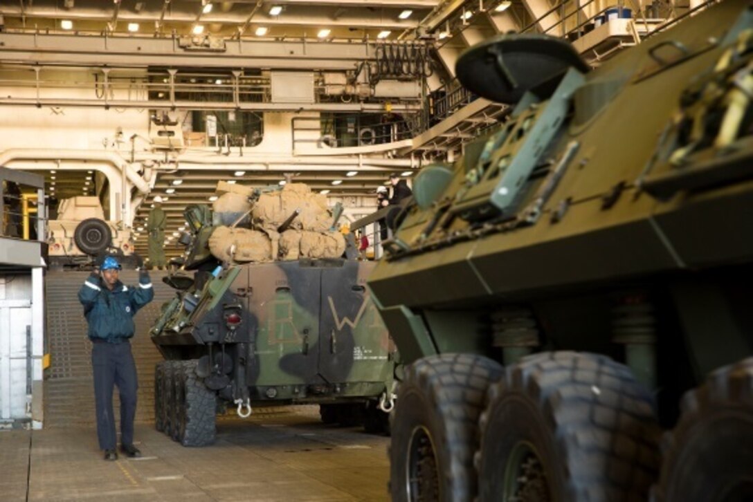 Marines with Combat Logistics Battalion 2, Combat Logistics Regiment 2, 2nd Marine Logistics Group, work with the Marines and sailors of the 24th Marine Expeditionary Unit as they load vehicles, equipment and personnel aboard the USS New York at the port in Morehead City, N.C., Dec. 13, 2014. Heavy equipment operators and embarkation specialists spent several days prior to the ship's arrival staging and organizing the gear. (U.S. Marine Corps photo by Cpl. James R. Smith/Released)