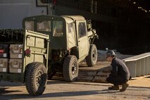 Marines with Combat Logistics Battalion 2, Combat Logistics Regiment 2, 2nd Marine Logistics Group, work with the Marines and sailors of the 24th Marine Expeditionary Unit as they load vehicles, equipment and personnel aboard the USS New York at the port in Morehead City, N.C., Dec. 13, 2014. (U.S. Marine Corps photo by Lance Cpl. Justin Updegraff/Released)