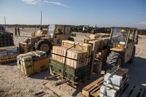 Heavy equipment operators with Combat Logistics Battalion 2, Combat Logistics Regiment 2, 2nd Marine Logistics Group, work with the Marines and sailors of the 24th Marine Expeditionary Unit as they load ammunition onto a Navy landing craft air cushion on the shore of Onslow Beach aboard Camp Lejeune, N.C., Dec. 16, 2014. Marines also transported ammunition through a helicopter support team from landing zone bluebird to the USS Iwo Jima. (U.S. Marine Corps photo by Cpl. James R. Smith/Released)