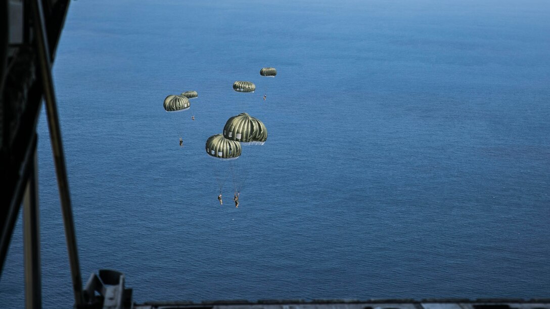 Marines parachute from the back of a KC-130J Super Hercules aircraft Nov. 20, 2014 over Ie Shima Training Facility, off the northwest coast of Okinawa, Japan. The training gave the Marines added experience with air drop operations while also maintaining their jump proficiency. The Marines are with 3rd Reconnaissance Battalion, 3rd Marine Division, III Marine Expeditionary Force. 