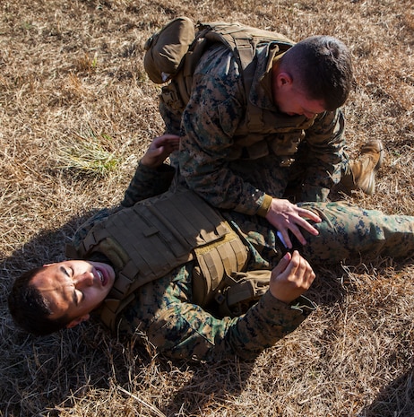 Two Marines with Alpha Company, 2nd Transportation Support Battalion, 2nd Marine Logistics Group practice tourniquet application during counter improvised explosive device training aboard Camp Lejeune, N.C. Marines with 2nd TSB conducted the exercise to improve readiness, unit cohesion and maintain their skills for future deployments. (U.S. Marine Corps photo by Cpl. Joshua W. Brown/Released)