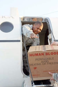 Sgt. 1st Class Michael Olezene, NCOIC of a mobile blood team, loads a box of "precious" cargo aboard a C-12 Huron from the Army National Guard's Washington Regional Flight Center during a recent blood run from Monterey, Calif., to Joint Base Lewis McChord, Wash.