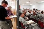 From left, D.C. Faber and Mike Bacon, both part of the Wyoming Military Department's "Warm Welcome Team" look over their lists of Soldiers to talk with during out-processing functions while transitioning through Fort Hood, Texas, March 29, 2010. The team was tasked with connecting with Wyoming Soldiers one-to-one in order to offer reintegration resources once Soldiers arrive home.
