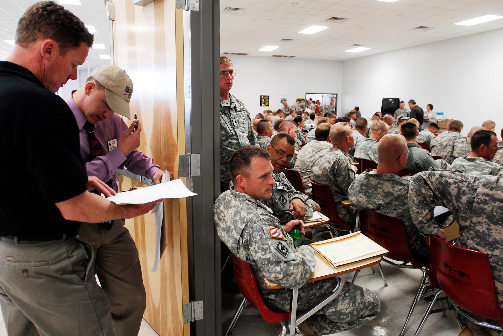 From left, D.C. Faber and Mike Bacon, both part of the Wyoming Military Department's "Warm Welcome Team" look over their lists of Soldiers to talk with during out-processing functions while transitioning through Fort Hood, Texas, March 29, 2010. The team was tasked with connecting with Wyoming Soldiers one-to-one in order to offer reintegration resources once Soldiers arrive home.