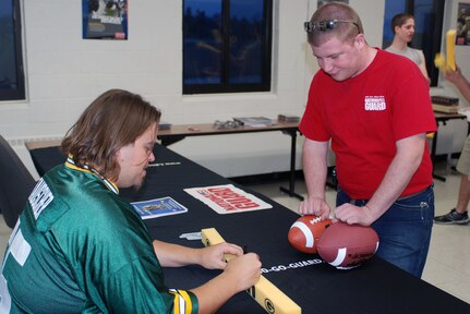 Green Bay Packer offensive lineman Mark Tauscher signs his autograph for a fan during a recent visit to the Wisconsin Army National Guard Armory in Racine, Wis. Tauscher took time to sign autographs following a talk he gave at the armory, sharing his experiences working to live what he called his dream - playing in the NFL.