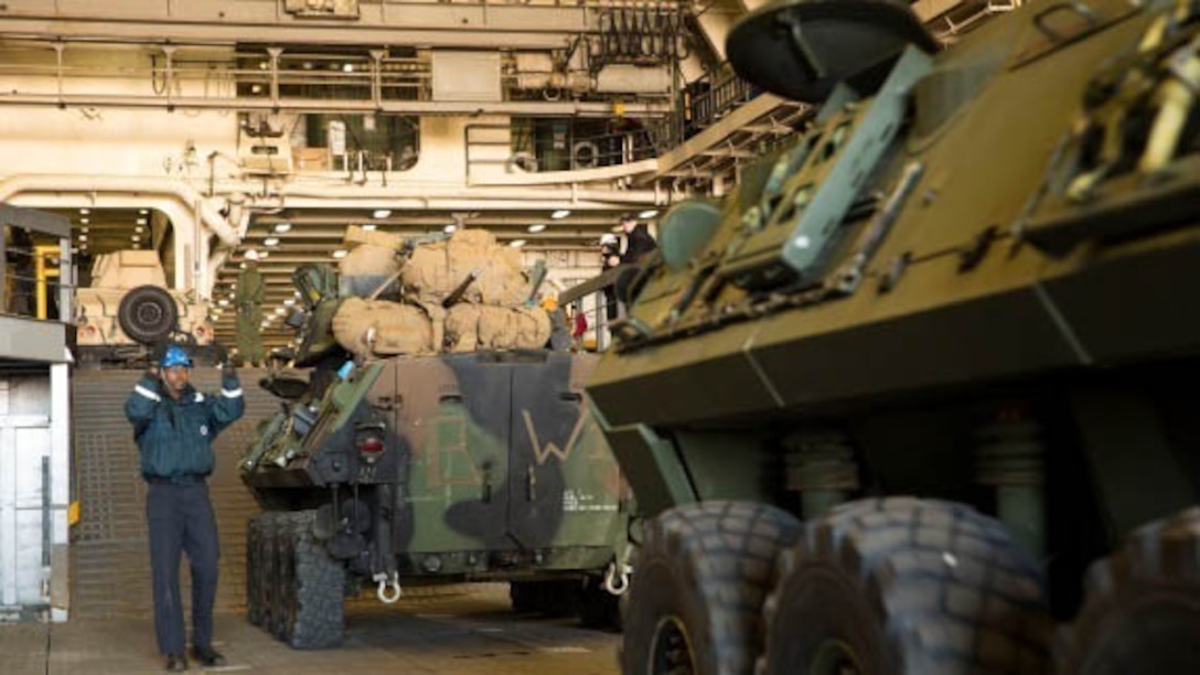Marines with Combat Logistics Battalion 2, Combat Logistics Regiment 2, 2nd Marine Logistics Group, work with the Marines and sailors of the 24th Marine Expeditionary Unit as they load vehicles, equipment and personnel aboard the USS New York at the port in Morehead City, N.C., Dec. 13, 2014. Heavy equipment operators and embarkation specialists spent several days prior to the ship's arrival staging and organizing the gear. 