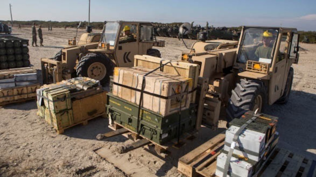 Heavy equipment operators with Combat Logistics Battalion 2, Combat Logistics Regiment 2, 2nd Marine Logistics Group, work with the Marines and sailors of the 24th Marine Expeditionary Unit as they load ammunition onto a Navy landing craft air cushion on the shore of Onslow Beach aboard Camp Lejeune, N.C., Dec. 16, 2014. Marines also transported ammunition through a helicopter support team from landing zone bluebird to the USS Iwo Jima. 