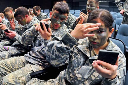 From right to left, North Dakota Recruit Training Battalion members Pvt. Nina Santiago, Pvt. Daniel Bettin and Pvt. Kurt Altenburg apply camouflage face paint during a "stripes-for-skills" event at the Armed Forces Reserve Center in Fargo, N.D., April 10, 2010. The North Dakota Army National Guard event is part of a program to offer new soldiers a chance to be promoted based on their basic Army knowledge and skills.