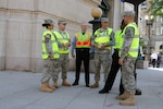 Members of the District of Columbia National Guard talk with officers from the Metropolitan Police Department's homicide branch while on duty at the nuclear summit in Washington, D.C., on April 12, 2010. The National Guard is supporting civilian authorities protecting 46 world leaders attending the summit.