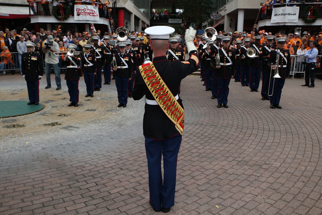 Gunnery Sgt. David Wilson, the Parris Island Marine Band Drum Major, leads the Marine band during a pep rally January 1, 2015 at the Jacksonville Landing in Jacksonville, Fla., for the 2015 TaxSlayer Bowl game. The Bands on Parade event included the Parris Island Marine Band, marching bands from the Universities of Tennessee and Iowa and high school bands from around the country. The Marine Corps has partnered with the bowl for nine consecutive years. (Official Marine Corps photo by Cpl. John-Paul Imbody)