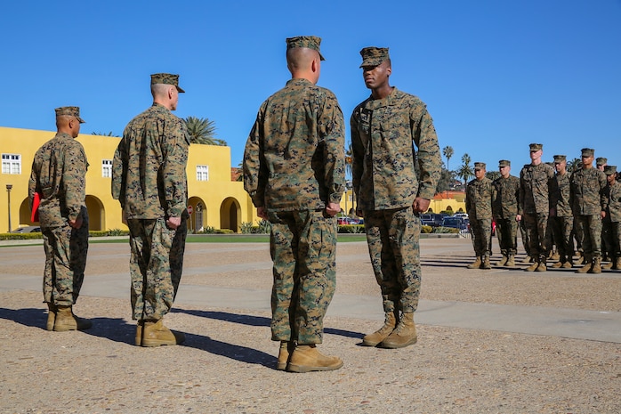 Cpl. Jason Martin, military police officer, Headquarters and Service Battalion, is called to the center to be awarded the Navy and Marine Corps Commendation Medal at Marine Corps Recruit Depot San Diego, Jan. 5.  Martin received the award for his heroic actions in saving the life of a woman caught in quickly rising flood waters.